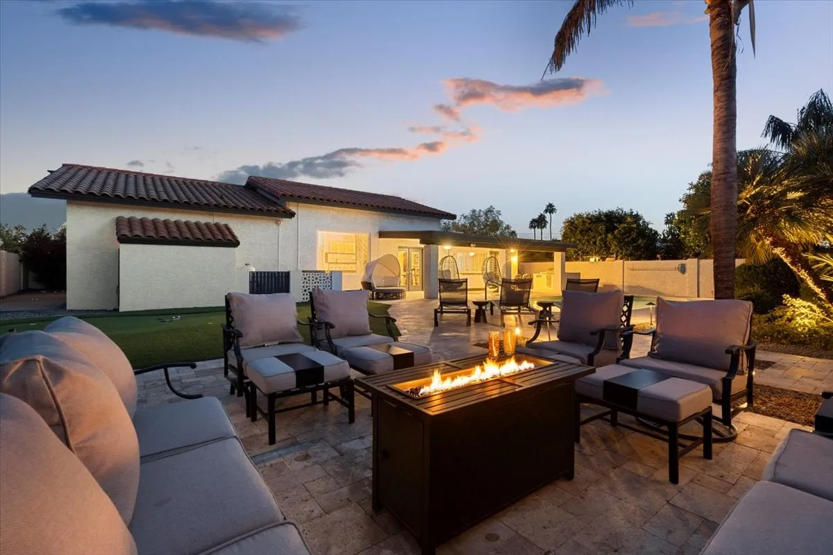 A cozy fire pit area with an inviting outdoor seating arrangement set amidst the landscaped backyard. The image hints at sunset views and encourages conversation and relaxation under the stars.