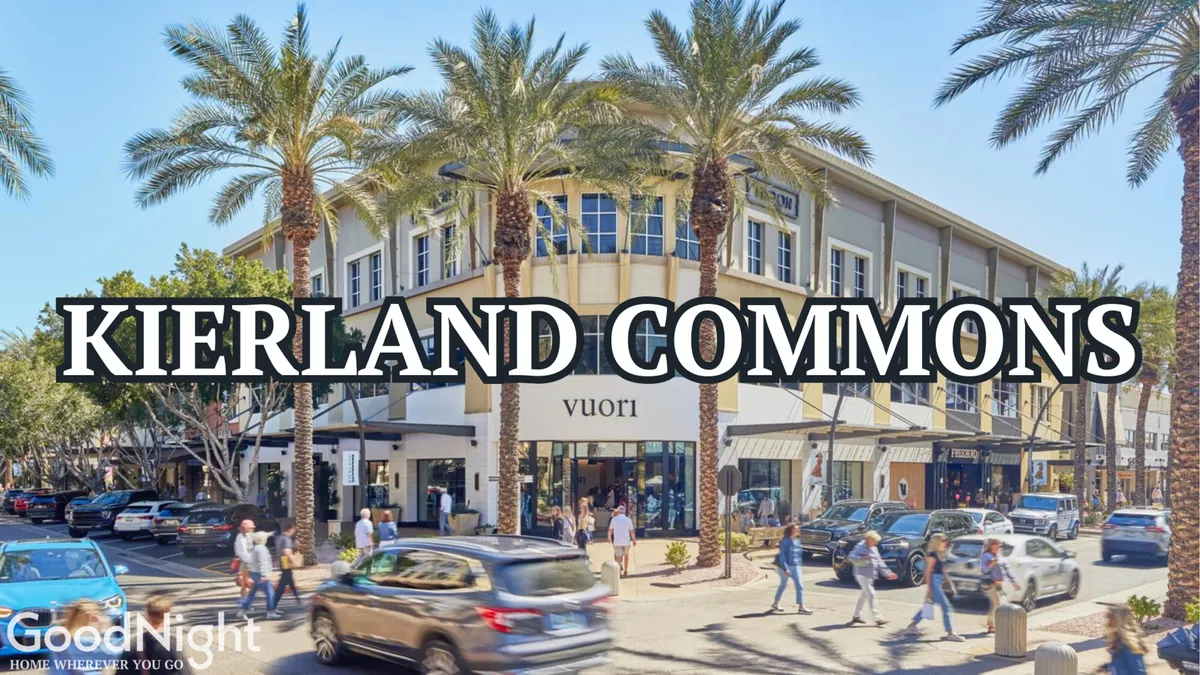 This lively exterior shot showcases the Kierland Commons building surrounded by palm trees, vehicles, and people strolling. The scene buzzes with activity, highlighting a vibrant local shopping and dining destination within walking distance.